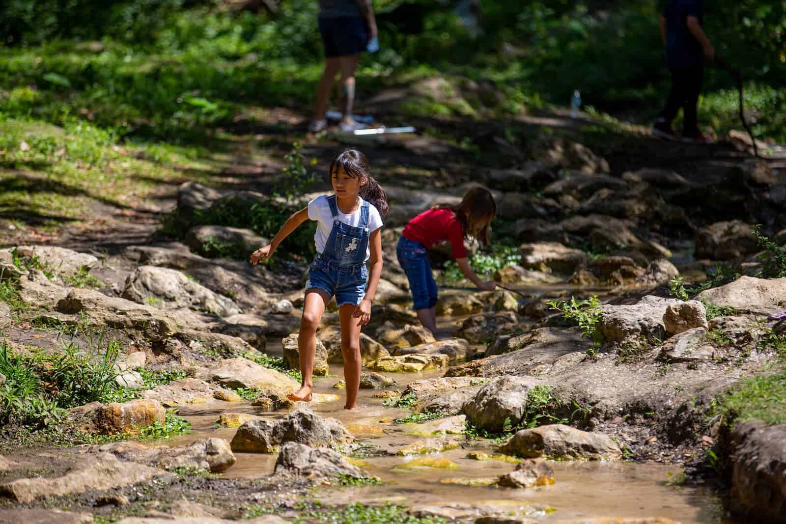 girl playing in a small brook